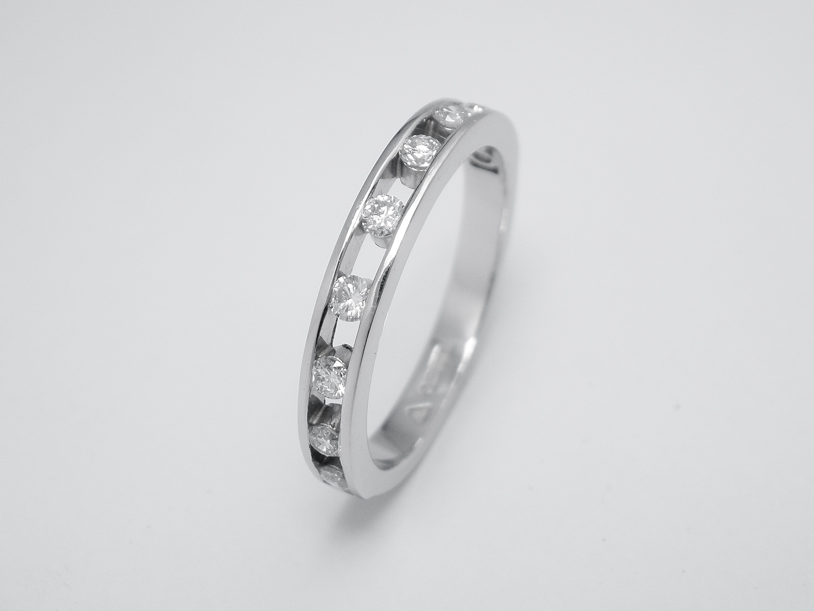 Platinum spaced channel set round brilliant cut diamond eternity ring.