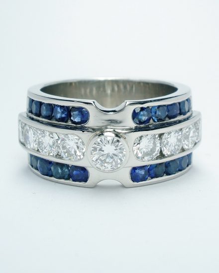 Brilliant cut diamond and round sapphire triple channel set ring mounted in palladium & platinum.