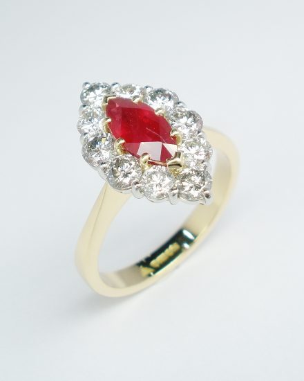 Marquise ruby and round brilliant cut diamond cluster ring mounted in 18ct. yellow gold and platinum.