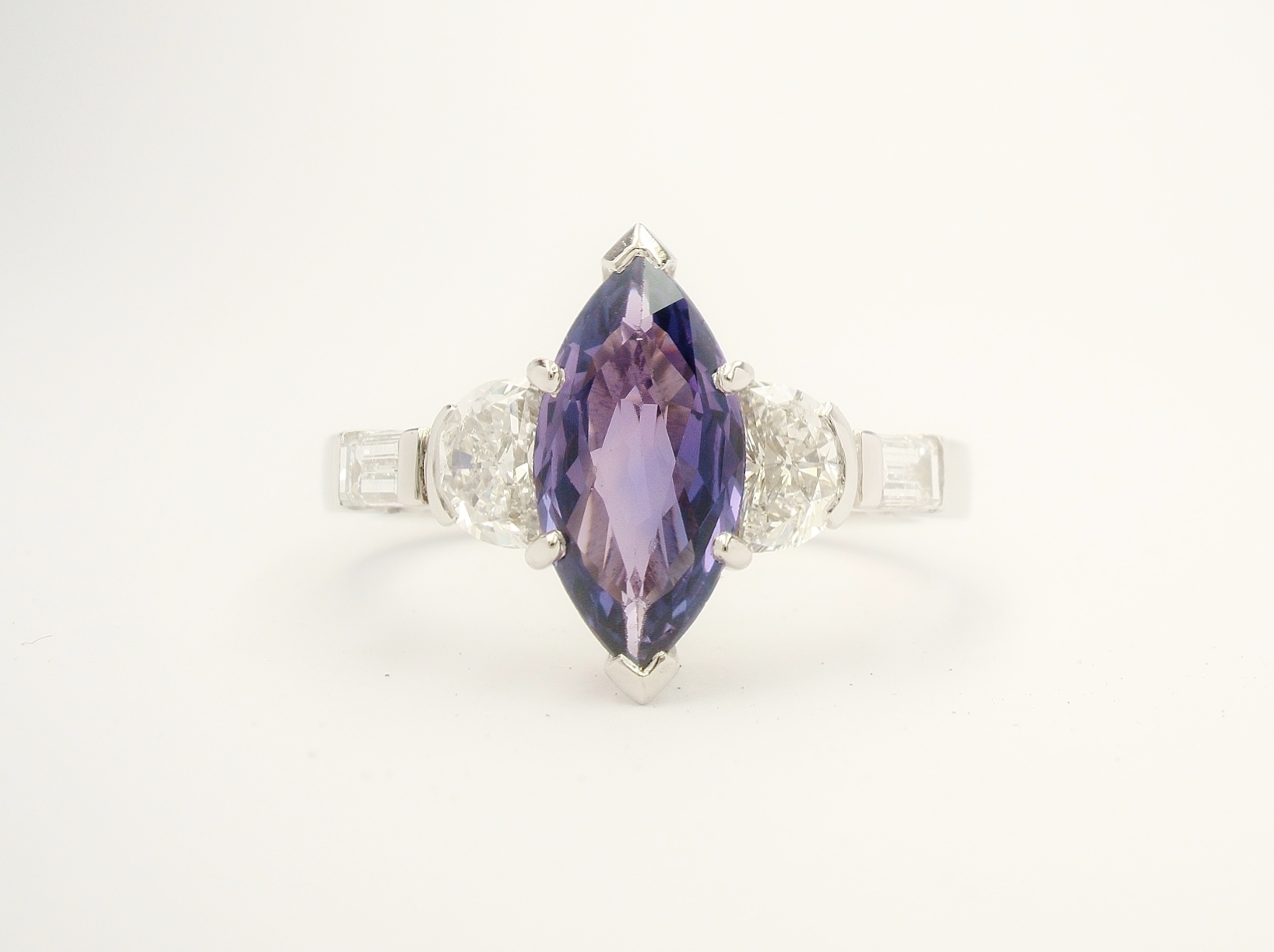 Purple Marquise cut sapphire, half moon cut diamond & baguette diamond 5 stone ring mounted in platinum.