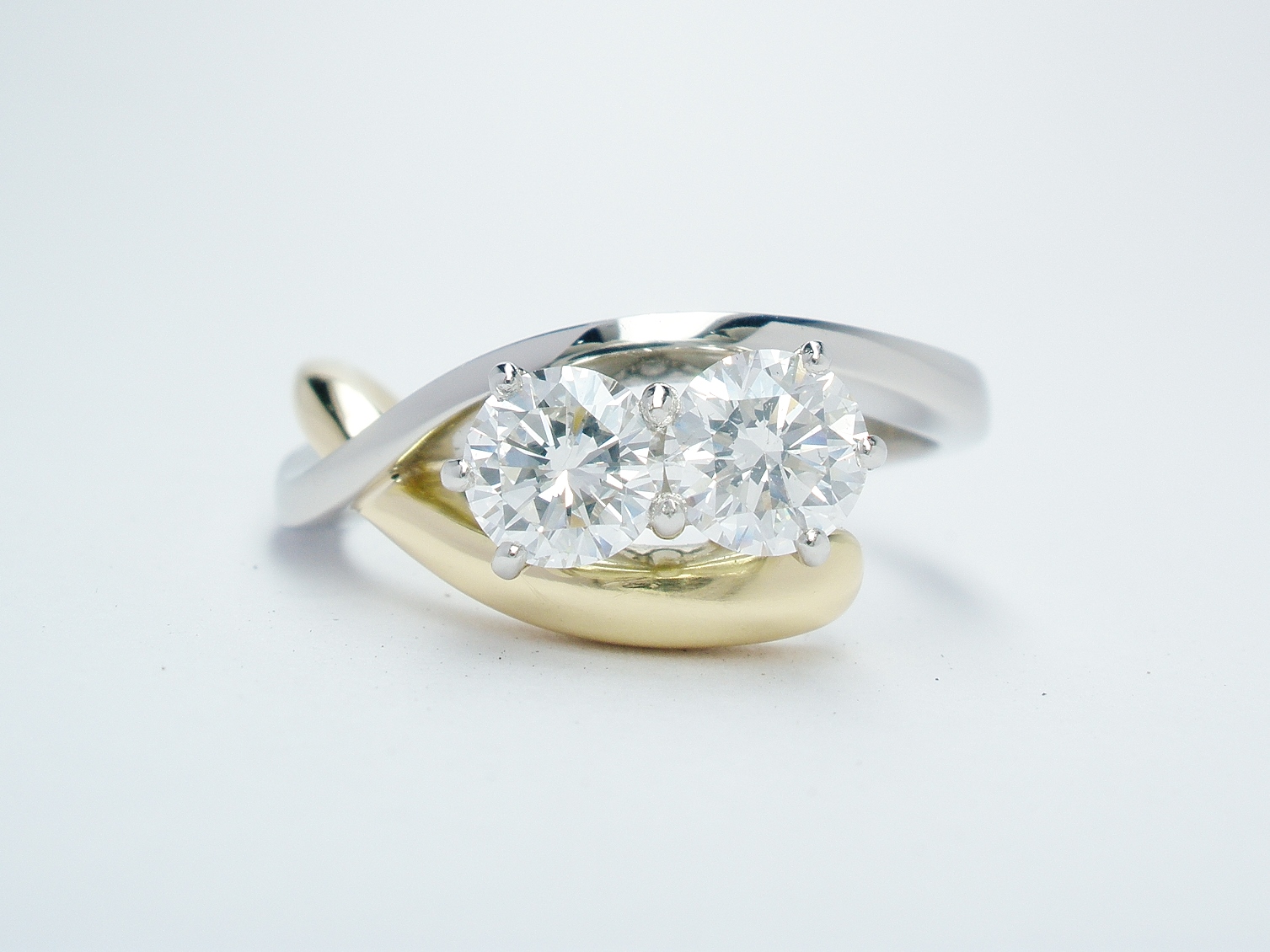 Platinum and 18ct. yellow gold open cross-over 2 stone round brilliant cut diamond ring. Ideal diamond sizes from 0.35cts. to 0.45cts.