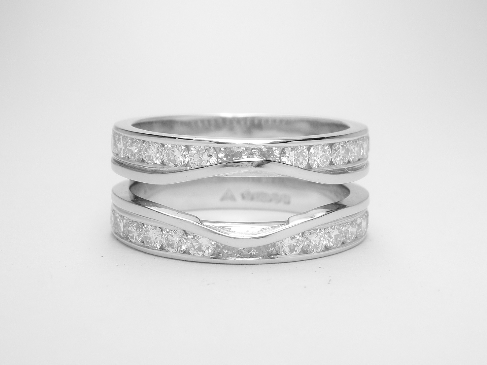 Double 'Embrace' platinum wedding ring channel set with round brilliant diamonds & created to receive the insertion of a phoenix cut and baguette diamond.