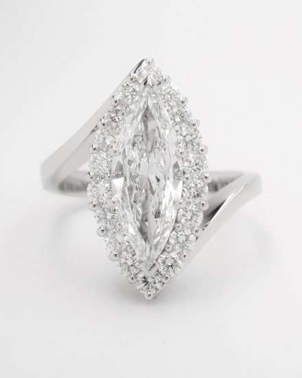 A marquise diamond and round brilliant cut diamond cross-over style ring mounted in platinum.