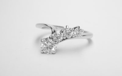A 4 stone round brilliant cut diamond 'comet' engagement ring mounted in platinum.