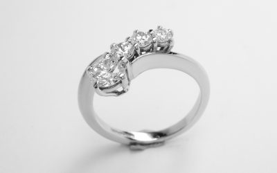 A 4 stone round brilliant cut diamond 'comet' engagement ring mounted in platinum.