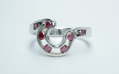 A pink diamond 7 stone open channel set shaped wedding ring shaped to fit around 4 stone comet engagement ring.