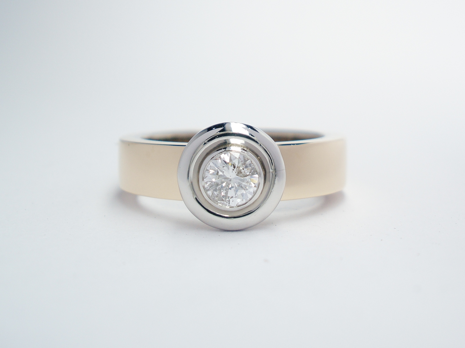 A single stone round brilliant cut diamond 'Doughnut' style ring mounted in 9ct. yellow gold and platinum.