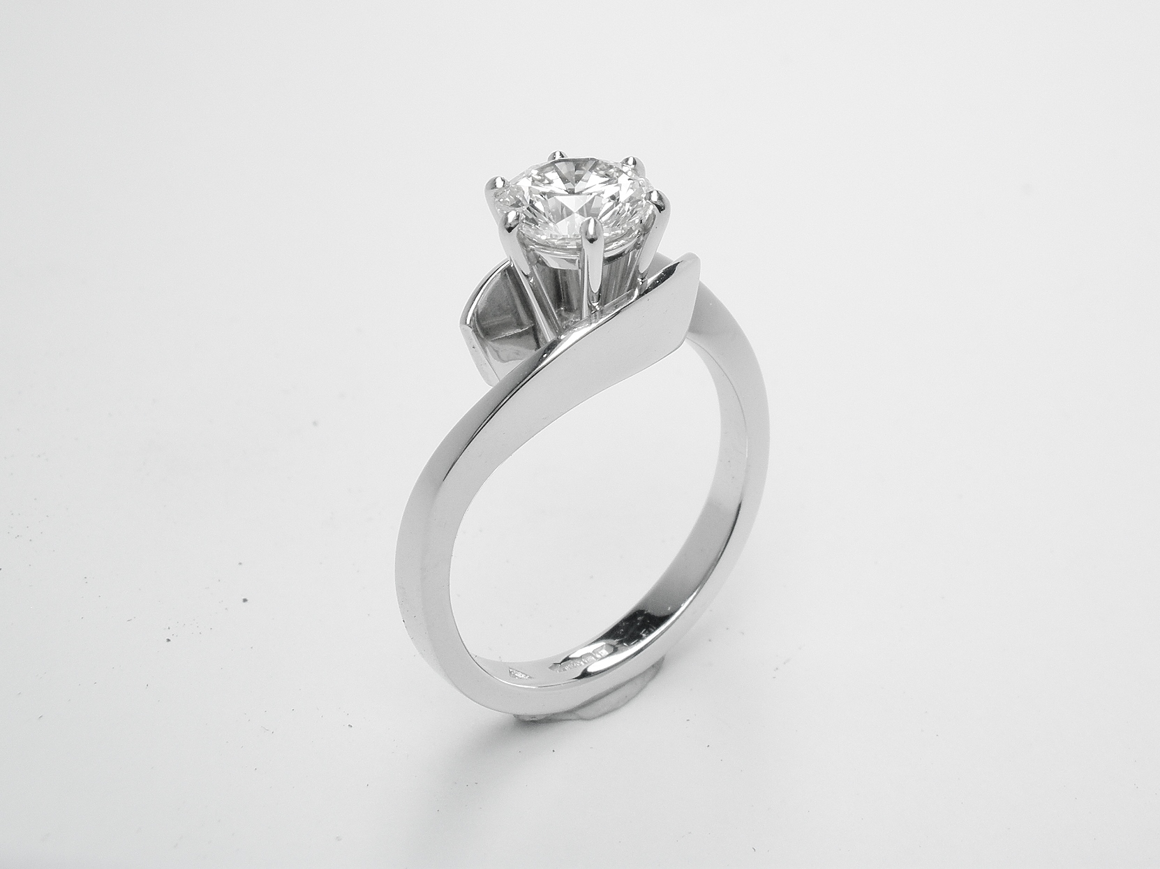 1.02ct. round brilliant cut diamond single stone open cross-over style ring mounted in platinum.