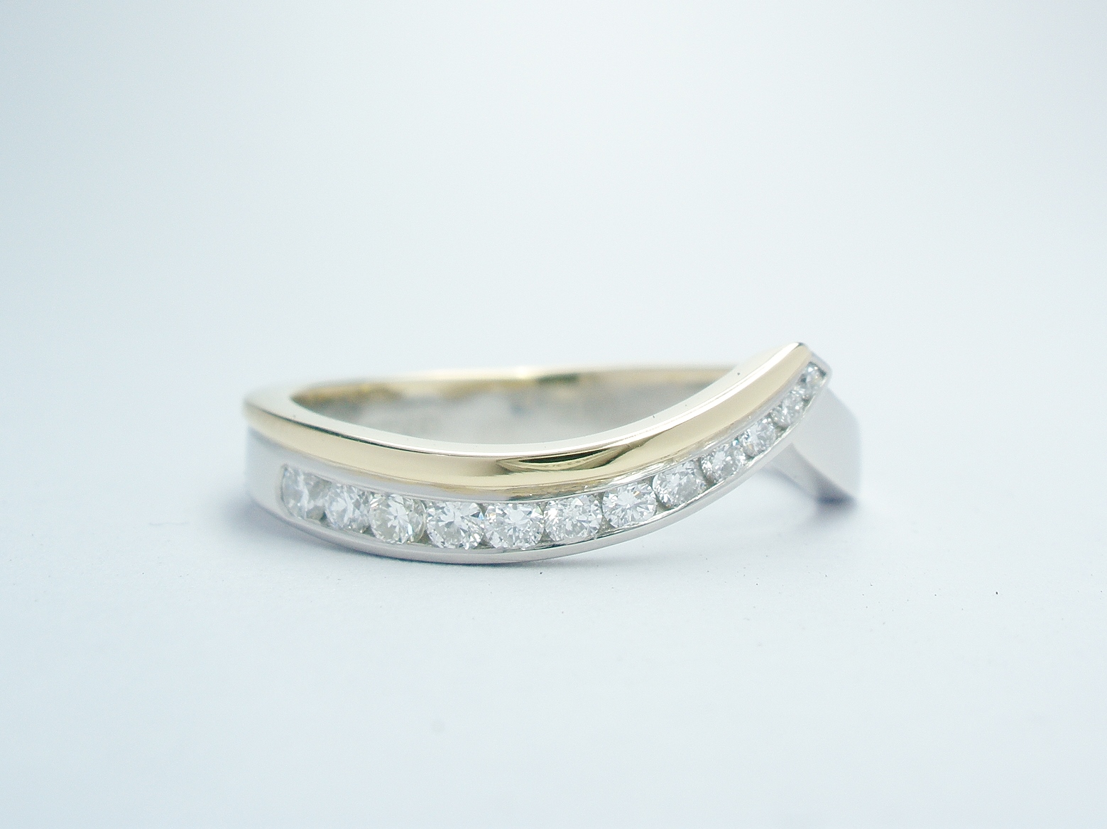 Palladium & 18ct yellow gold wedding ring shaped to fit around 2 stone open cross-over ring set with 12 round brilliant cut diamonds that taper in size.