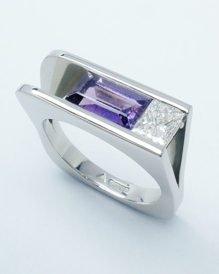 A purple baguette sapphire and princess cut diamond plateau topped square ring mounted in palladium.
