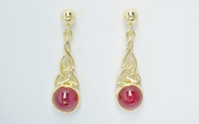 A pair of 18ct yellow gold hand carved Celtic pattern drop earrings set with cabochon rubies.