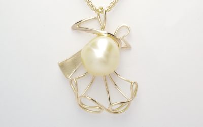 A golden pearl 'Ballroom Dance' style figurine pendant mounted in 9ct yellow gold.