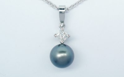 A black Tahitian pearl and princess cut diamond pendant mounted in platinum