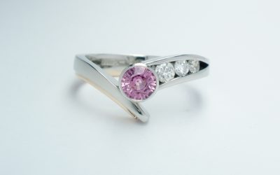 A round pink sapphire and diamond 4 stone ring mounted in palladium, platinum & 9ct red gold.