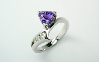 A trilliant purple sapphire and diamond 4 stone ring mounted in palladium and platinum and shaped to fit with the pink sapphire and diamond 4 stone ring.