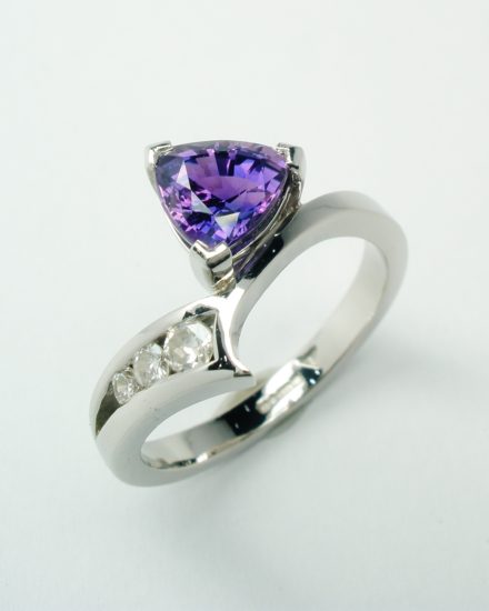 A trilliant purple sapphire and diamond 4 stone ring mounted in palladium and platinum and shaped to fit with the pink sapphire and diamond 4 stone ring.
