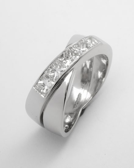 A 5 stone channel set princess cut diamond 'X' style ring mounted in platinum.