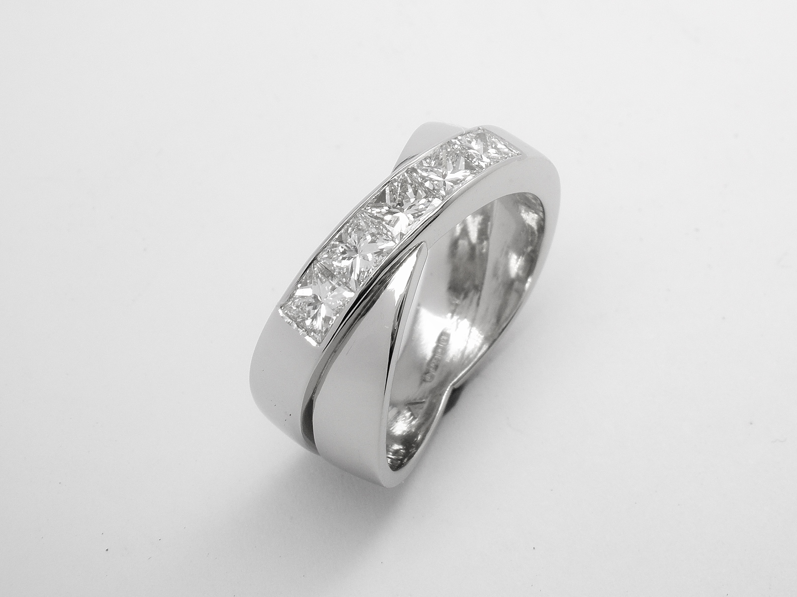 A 5 stone channel set princess cut diamond 'X' style ring mounted in platinum.