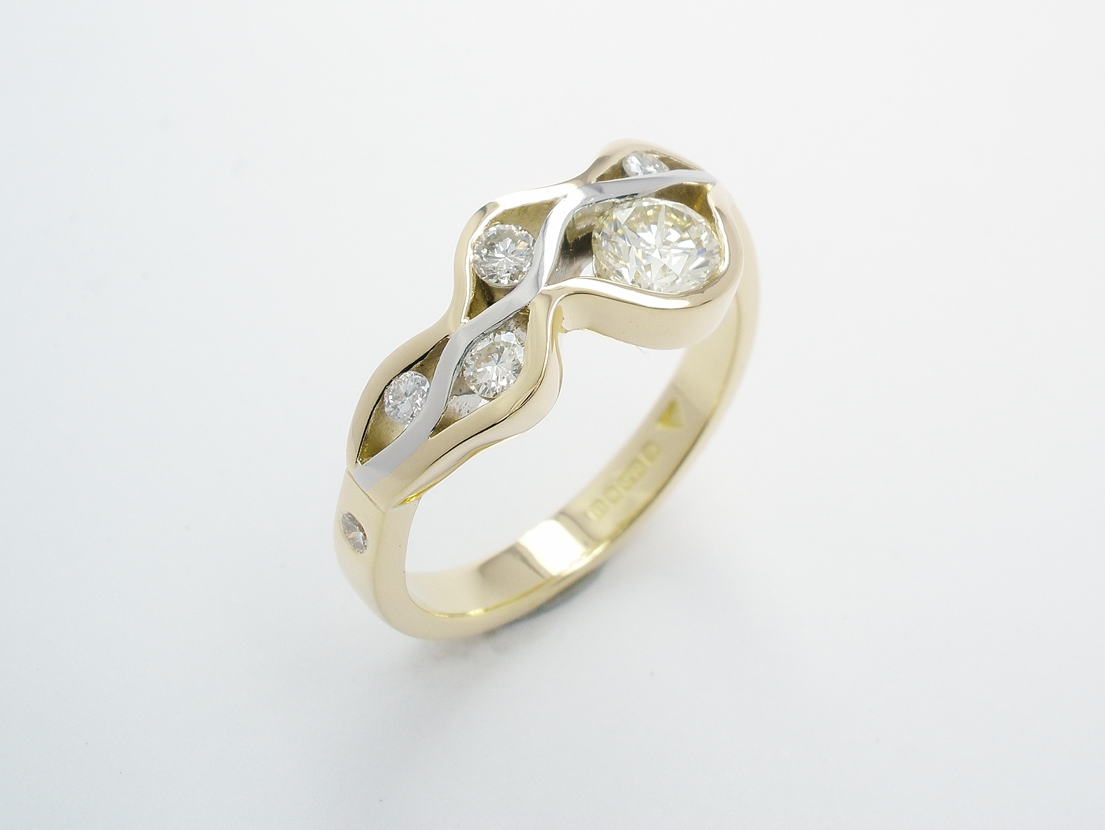 A 6 stone round brilliant cut diamond 'wave' style ring mounted in 18ct. yellow gold and platinum.