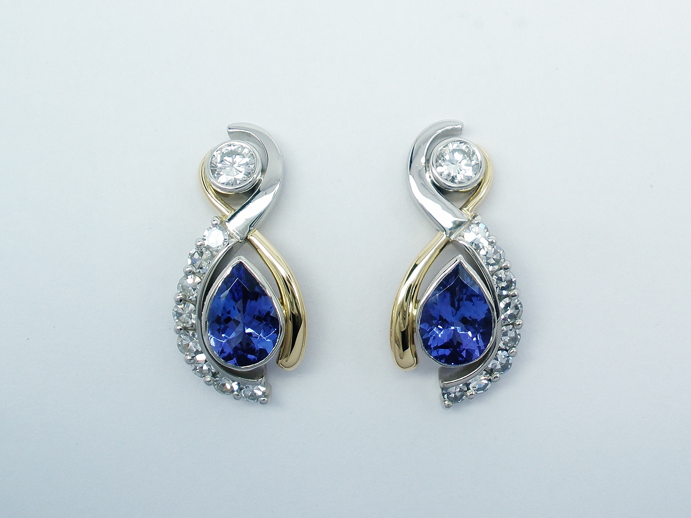 Pear tanzanite and round brilliant cut diamond ear studs mounted in platinum and 18ct. yellow gold.