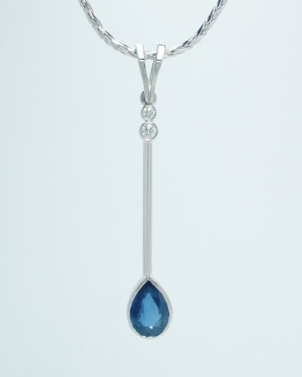 A 3 stone pear shaped sapphire and round brilliant cut pendulum style pendant mounted in palladium and platinum.