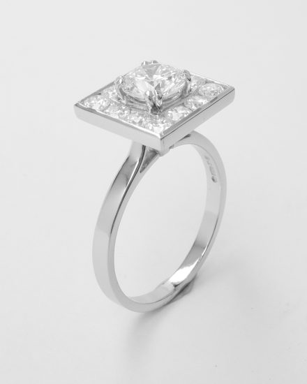 A 13 stone round brilliant cut diamond square channel set ring mounted in platinum.