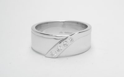 A gents platinum wedding ring flush set with 4 round brilliant cut diamonds that taper in size.