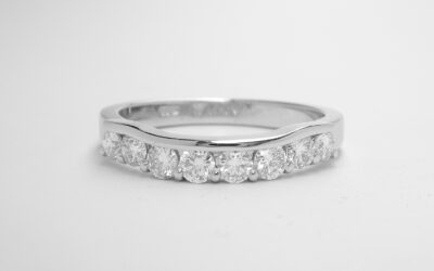 Platinum 8 stone part channel set diamond ring shaped to fit around a 3 stone diamond engagement ring.