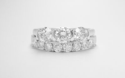 Platinum 8 stone part channel set diamond ring shaped to fit around a 3 stone diamond engagement ring.