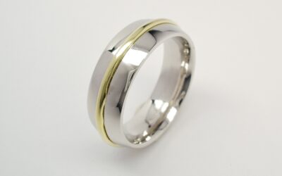 A platinum court sectioned wedding ring with an 18ct. Green gold wire inlayed in the centre.