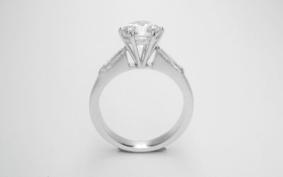After The 1.50cts. round brilliant cut diamond set in a handmade higher platinum setting inserted successfully between the original tapered baguette shouldered 18ct white gold mount.
