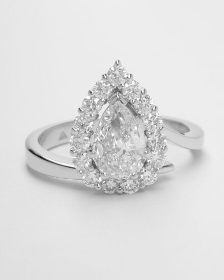 A 16 stone pear shaped 'halo' cluster straight wishbone cross-over style ring, mounted in platinum.