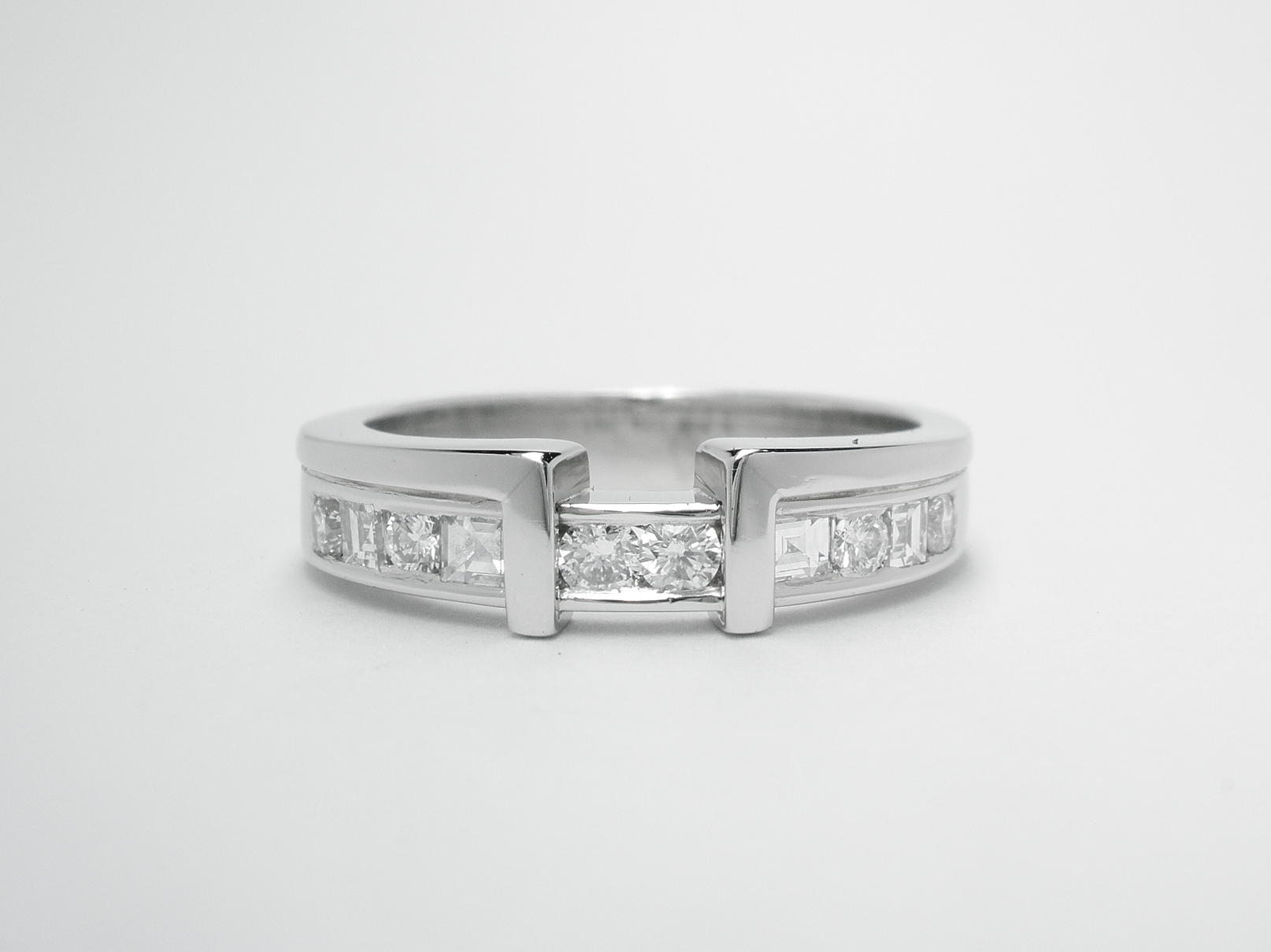 A platinum 10 stone square cut & round brilliant cut diamond wedding ring shaped to fit around a single stone princess cut engagement ring.