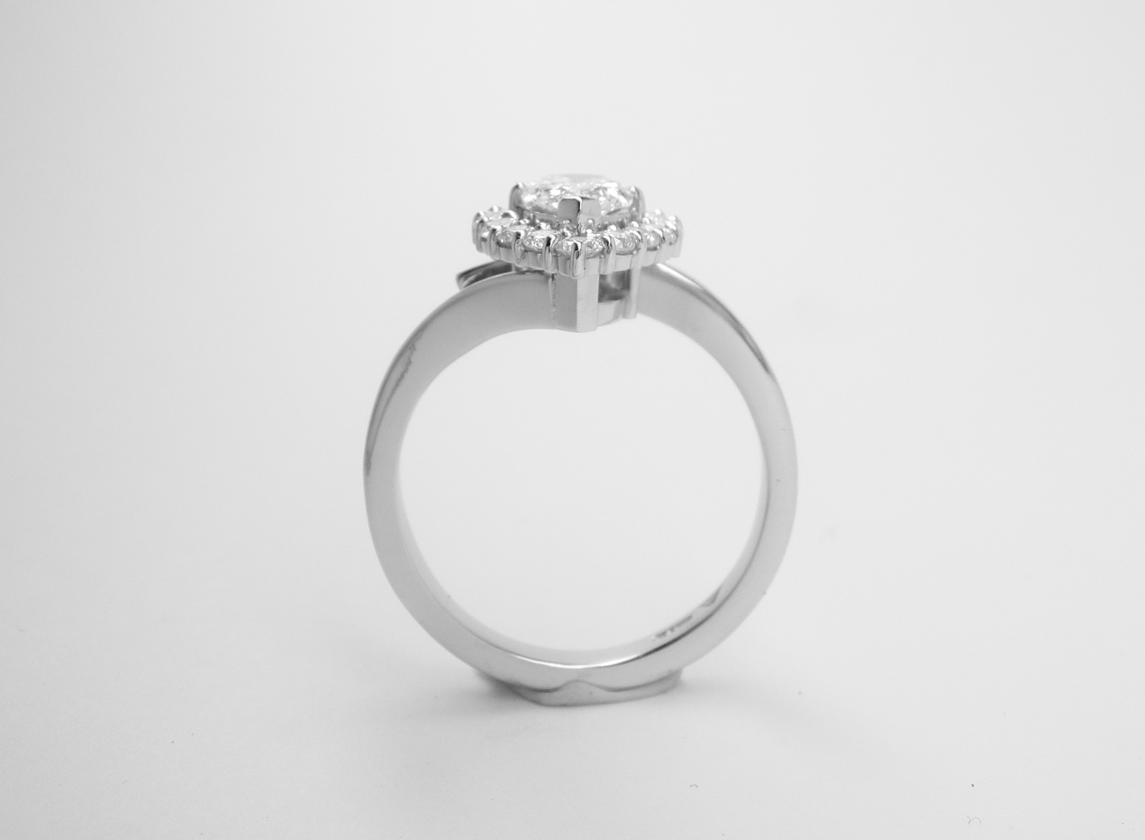 A 16 stone pear shaped 'halo' cluster straight wishbone cross-over style ring, mounted in platinum.