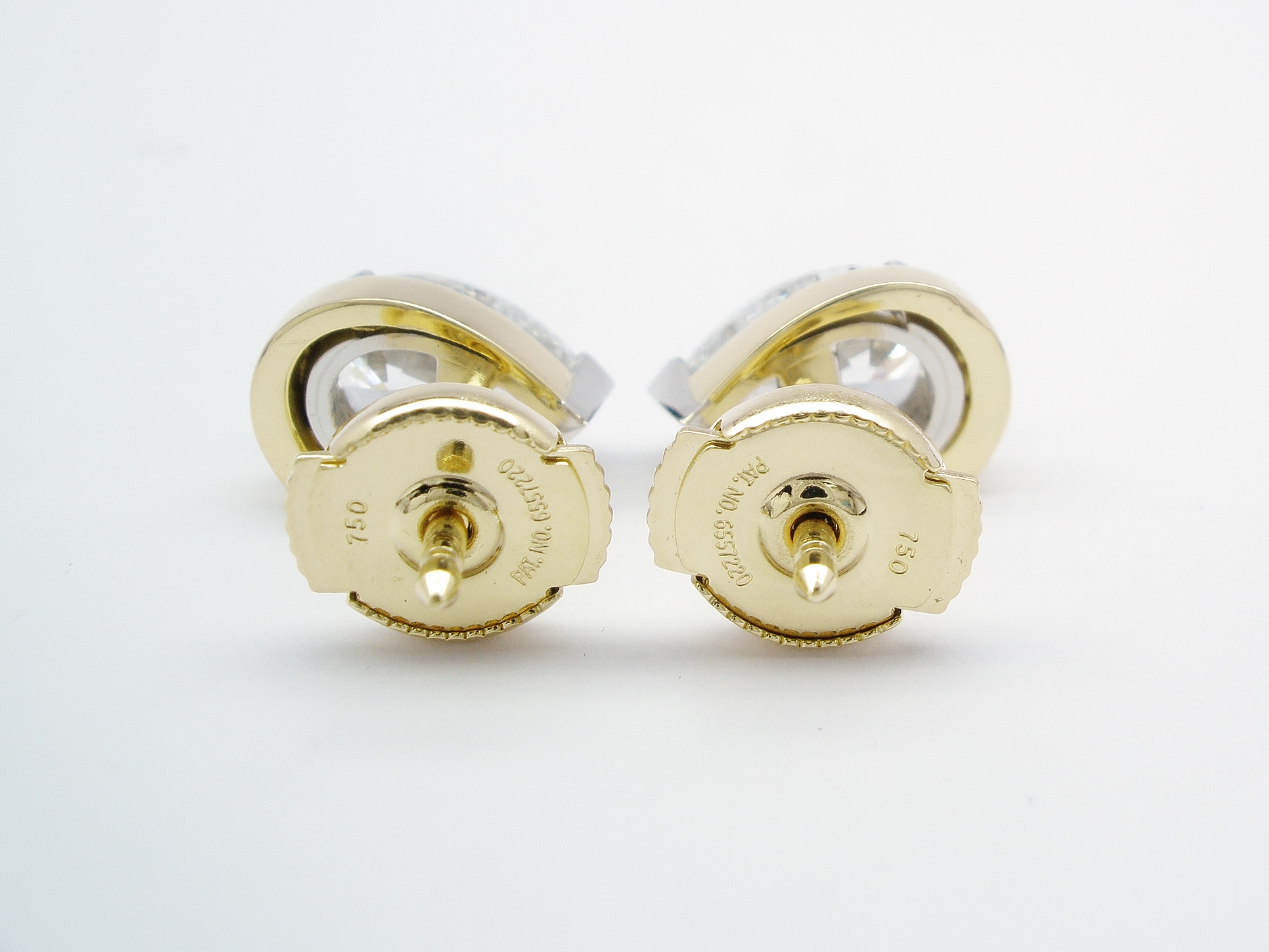 A pair of 1.00ct. pear shaped diamond ear studs mounted in platinum and 18ct. yellow gold with 'Guardian' safety spring fittings