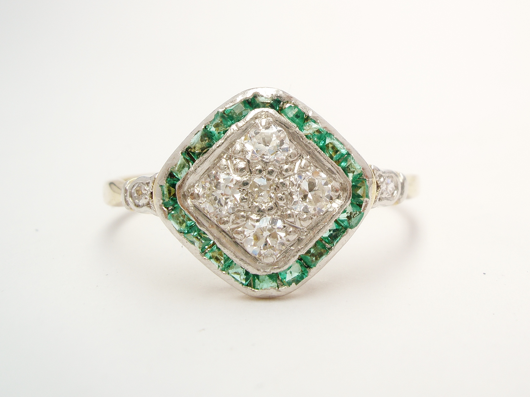 An emerald and diamond cluster, finely made in 18ct. yellow gold & topped in platinum very worn and broken on underside.