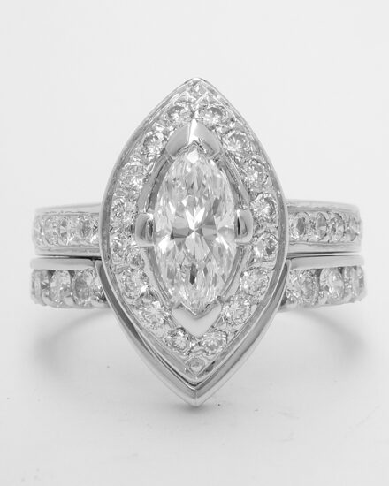 A 10 stone round brilliant cut part channel set platinum wedding ring with central 'V' wire to fit around a marquise cluster engagement ring.