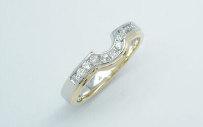 An 11 stone channel set round brilliant cut and princess cut diamond platinum and 18ct yellow gold shaped wedding ring.