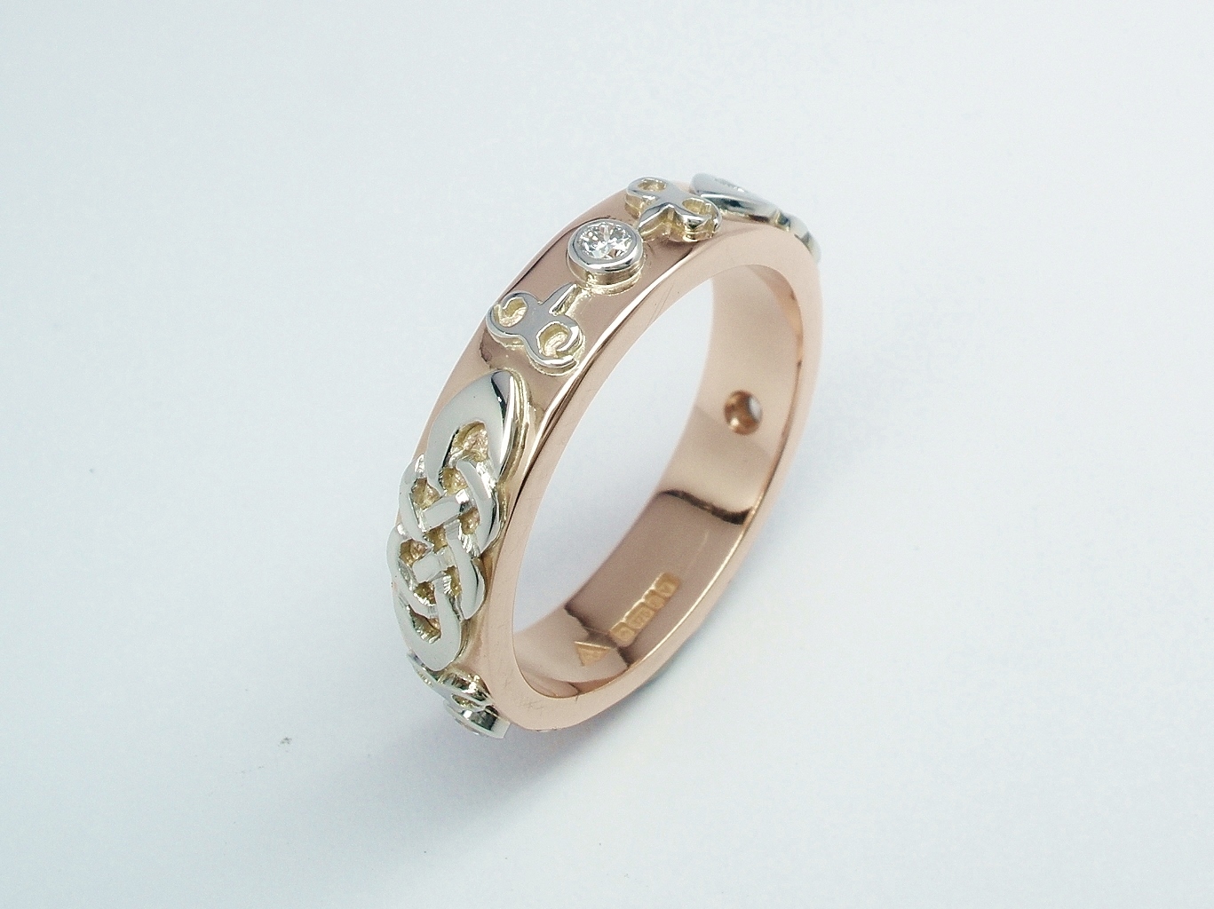 A diamond set red gold lady's wedding ring with platinum Celtic & Kazakh style motif overlays.