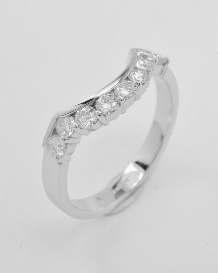 A platinum 9 stone part channel set round brilliant cut diamond wedding ring shaped to fit around a 5 stone baguette & triangle cut diamond ring.