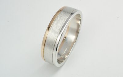 A gents platinum and 18ct. red gold wedding ring with a brushed centre and polished platinum and 18ct. red gold edges.