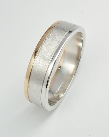 A gents platinum and 18ct. red gold wedding ring with a brushed centre and polished platinum and 18ct. red gold edges.