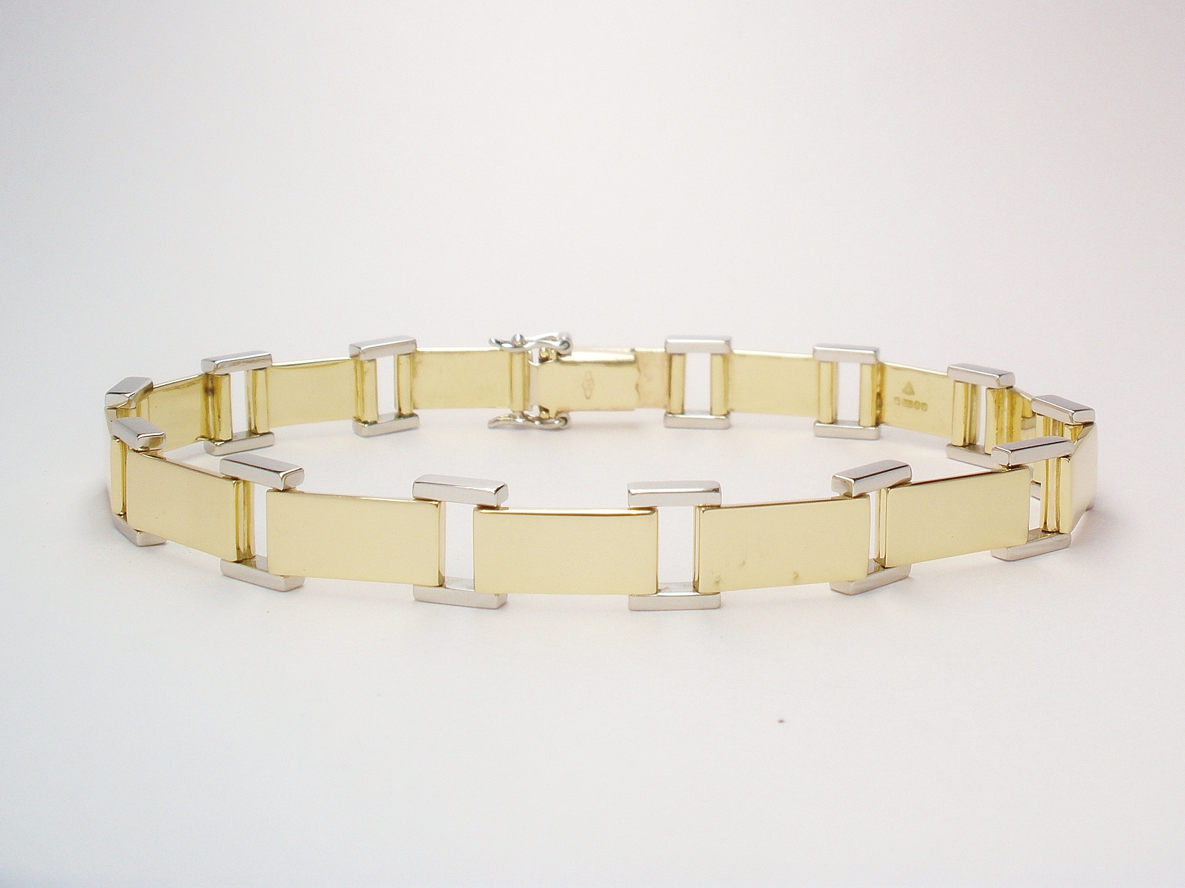 9ct gold and platinum panel bracelet with 9ct gold box catch and a pair of platinum figure 8 safety catches.