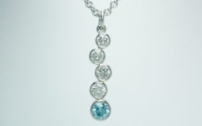 5 stone sky blue and white round brilliant cut diamond tumble pendant rub-over set in platinum