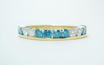 A 14 stone sky blue and white round brilliant cut part channel set ring mounted in 18ct. yellow gold and platinum.