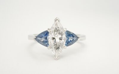 The 3 stone Marquise diamond and trilliant shaped sapphire ring mounted in platinum that has the 14 stone sapphire and diamond part channel set platinum ring shaped to fit.