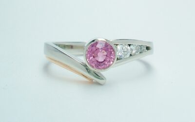 A round pink sapphire and diamond 4 stone wishbone cross-over style ring mounted in platinum and rose gold.