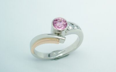 A round pink sapphire and diamond 4 stone wishbone cross-over style ring mounted in platinum and rose gold.