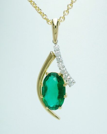 An 8 stone synthetic emerald and round brilliant cut diamond pendant mounted in 18ct yellow gold and platinum. The emerald was supplied by the client & sentimental to them.