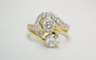 A 13 stone round brilliant cut diamond channel and part channel set ring mounted in 18ct. yellow gold and platinum and shaped to fit around a 2 stone cross-over engagement ring.